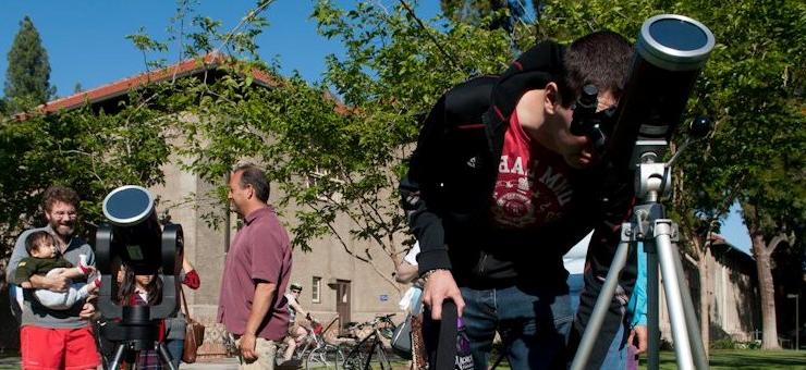 Male student looks into a telescope.