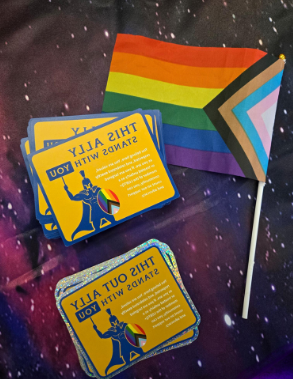 Collage featuring the progress pride flag, and stickers labled "This ally stands with you" and "This out ally stands with you."