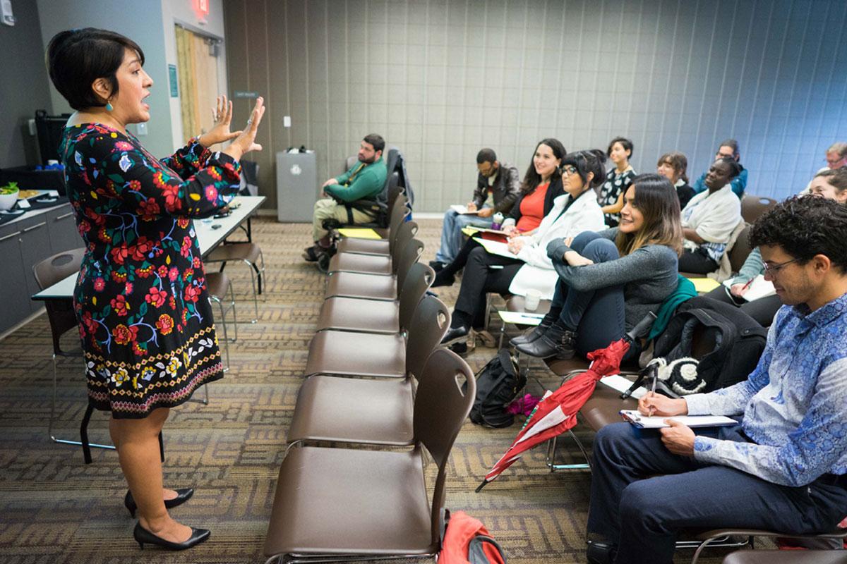 Magdalena L. Barrera speaking and gesturing with hands to an audience.